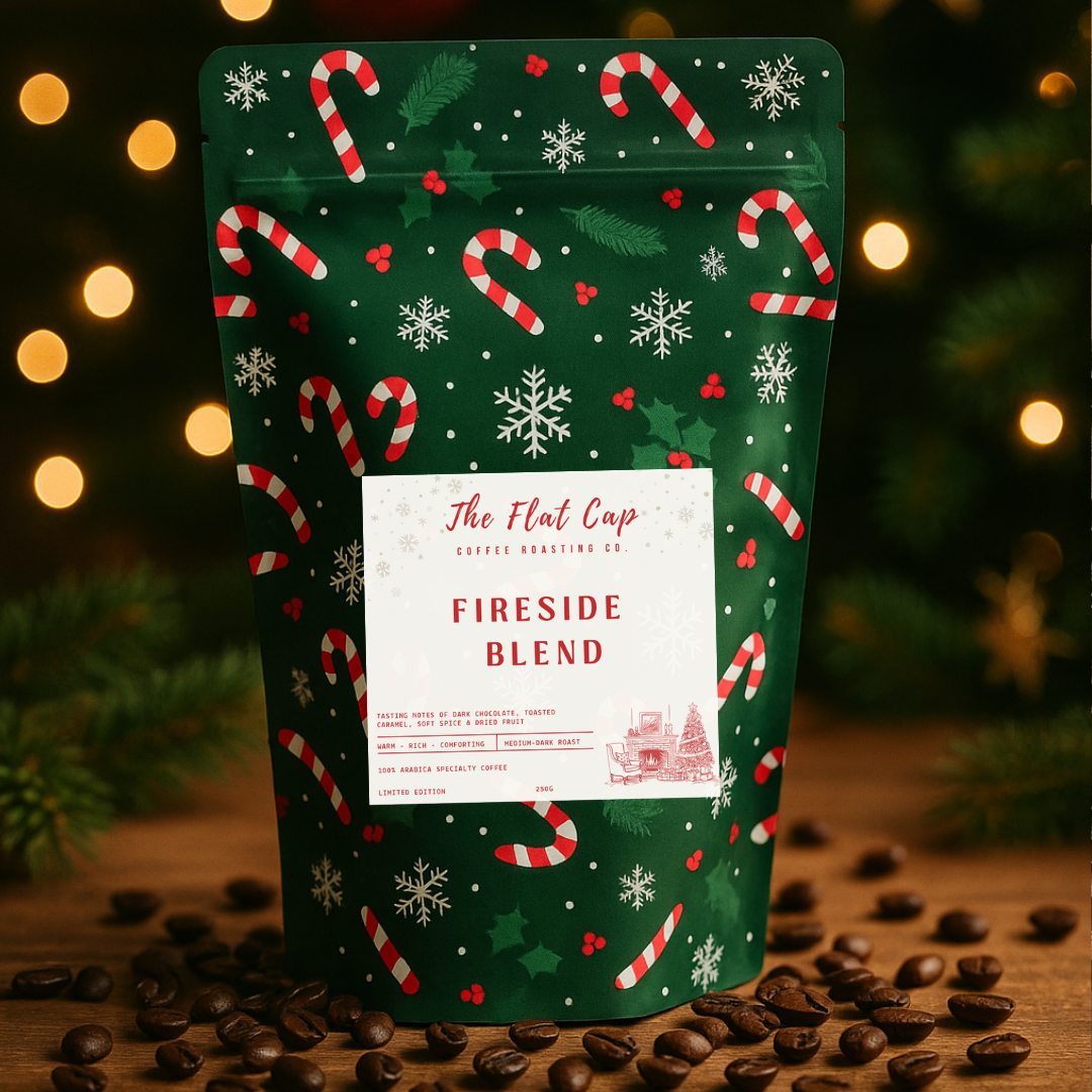 Christmas-themed coffee bag labeled 'Fireside Blend' with candy cane and snowflake design on a wooden surface with coffee beans.