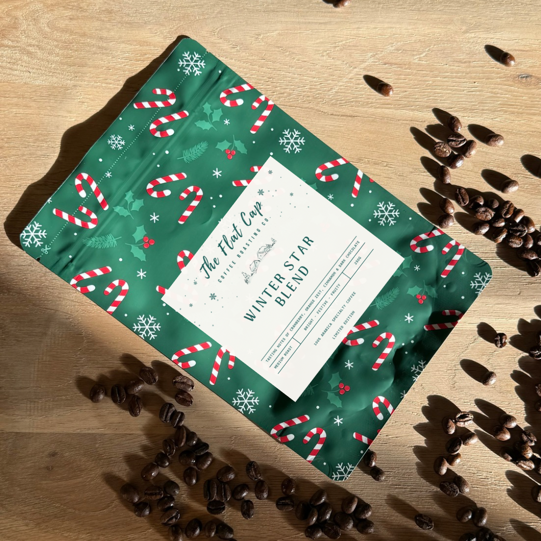 Green holiday-themed coffee bag with candy cane pattern on a wooden surface with coffee beans.