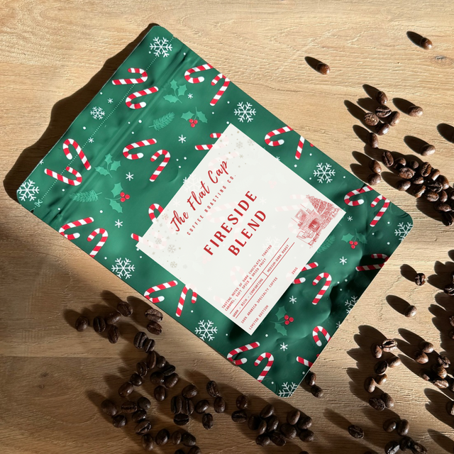 Coffee package with festive design on a wooden surface with coffee beans.