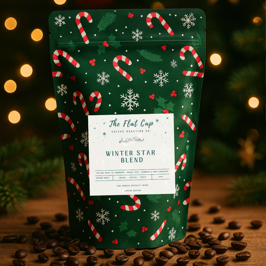 Coffee bag with Christmas design on a wooden surface with coffee beans and blurred lights in the background