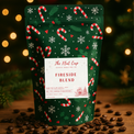 Christmas-themed coffee bag labeled 'Fireside Blend' with candy cane and snowflake design on a wooden surface with coffee beans.