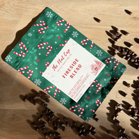 Coffee package with festive design on a wooden surface with coffee beans.